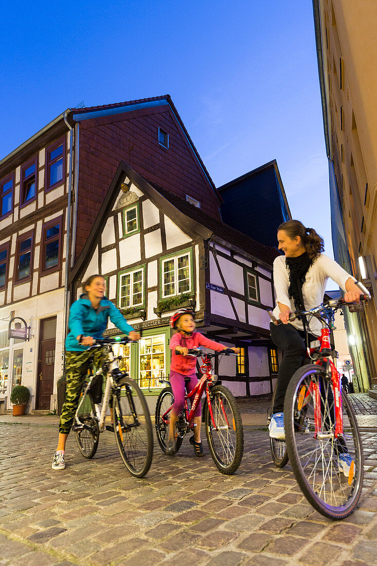 Family, bicycles, in front of Schwerin's oldest timbered house from 1698, downtown Schwerin, old town, street Buschstrasse, timbered house, provincial capital, Mecklenburg lakes, Schwerin, Mecklenburg-West Pomerania, Germany, Europe