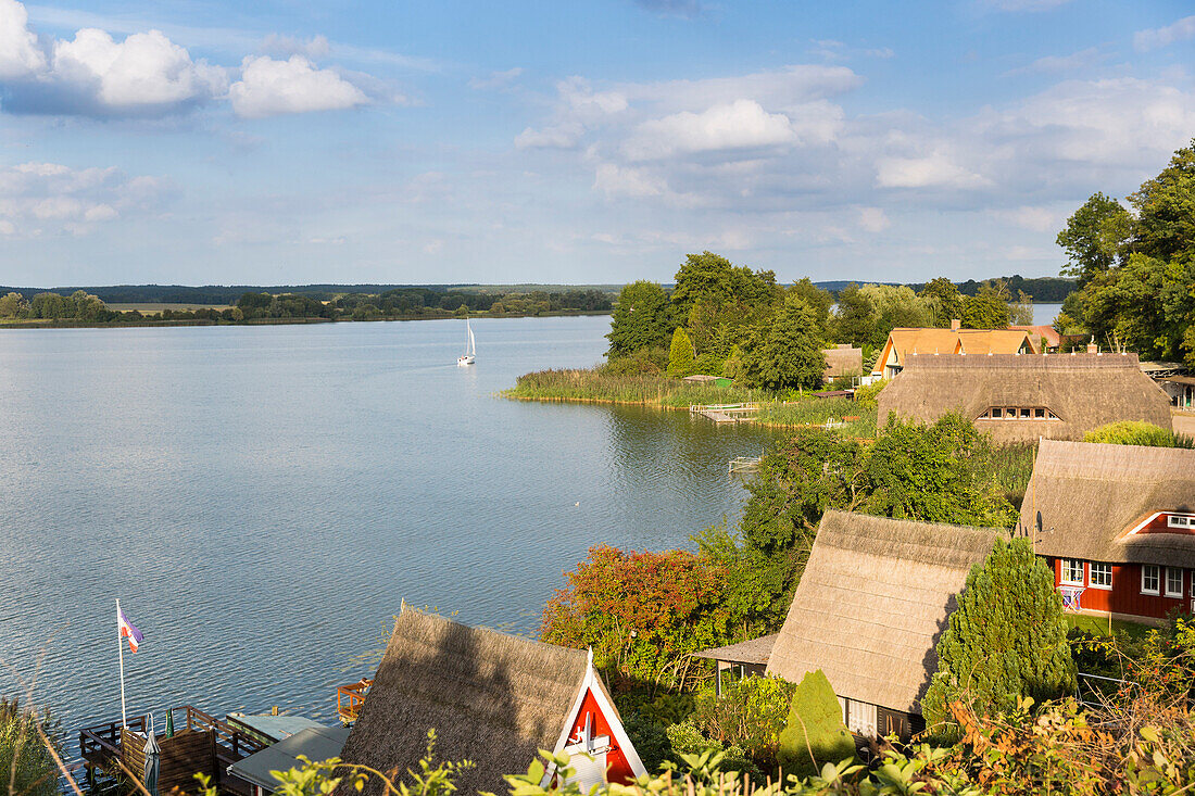 Boat houses, thatched roof, sailing boat, lake Sternberger See, Mecklenburg lakes, Sternberg, Mecklenburg-West Pomerania, Germany, Europe