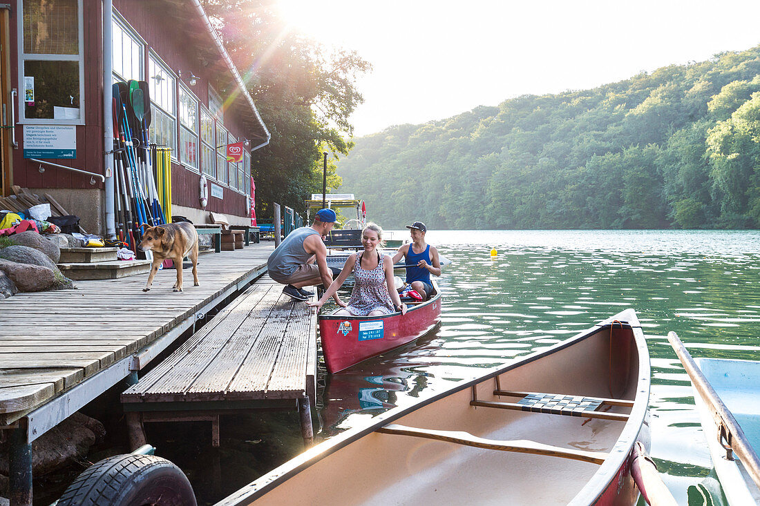 Canoing, girl and boy in red boat, landing, ferry, boat house, kayak, crystal clear green water, lake Schmaler Luzin, holiday, summer, swimming, MR, Feldberg, Mecklenburg lakes, Mecklenburg lake district, Mecklenburg-West Pomerania, Germany, Europe