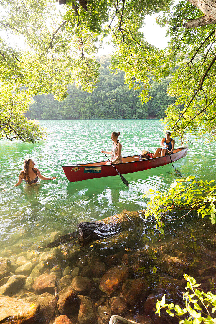 Canoing, girl and boy in red boat, women swimming, kayak, crystal clear green water, lake Schmaler Luzin, holiday, summer, swimming, MR, Feldberg, Mecklenburg lakes, Mecklenburg lake district, Mecklenburg-West Pomerania, Germany, Europe
