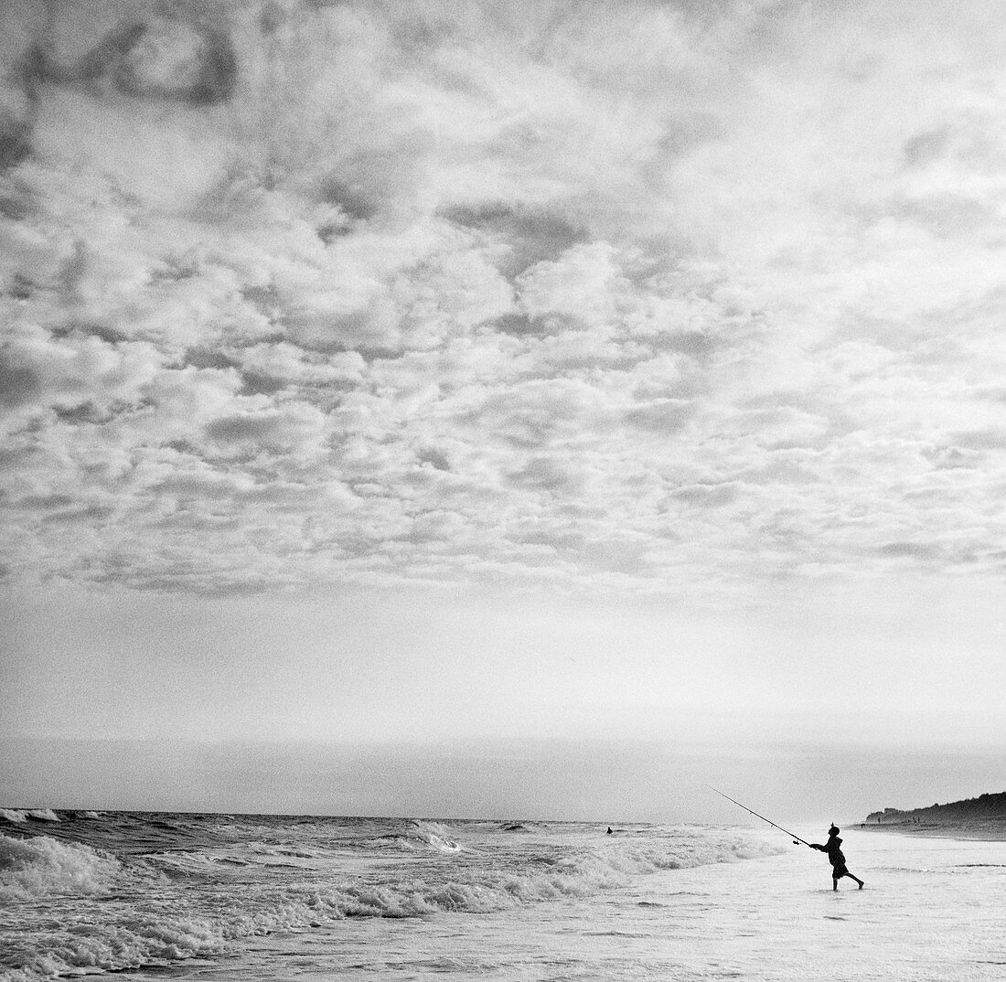 A boy casts into the surf on a beach in Montauk, NY.