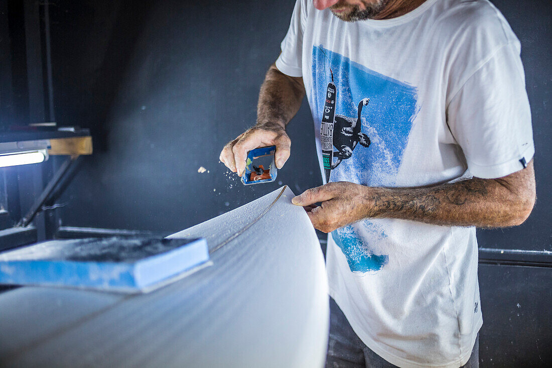 Close-up Of Surfboard Shaper Hand Working On Surfboard