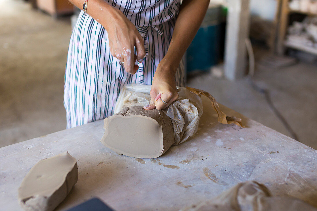 Young Woman Giving Shape To Clay In Ceramic Workshop