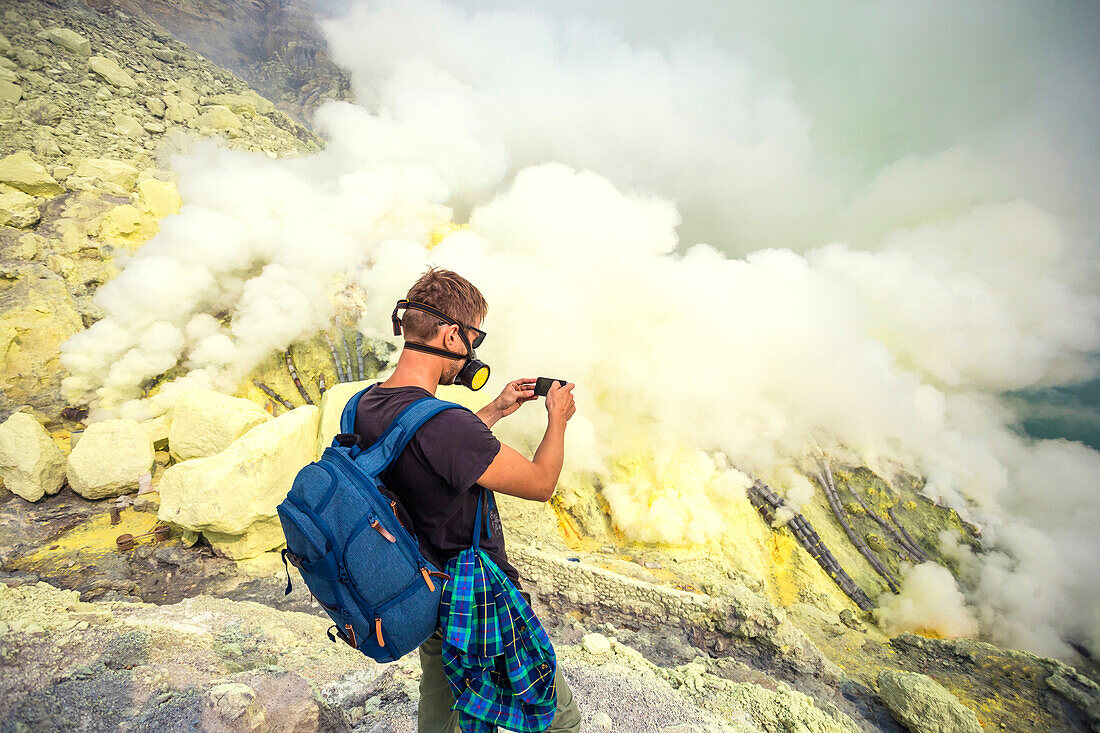 Person Taking Picture Of Sulfur Dioxide Smoke In Volcano Kawah Ijen