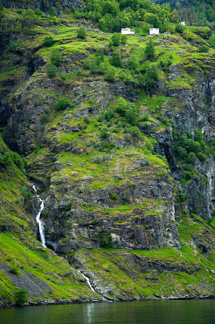 A House On A Cliff Above A Waterfall Along The Sognefjord In Norway
