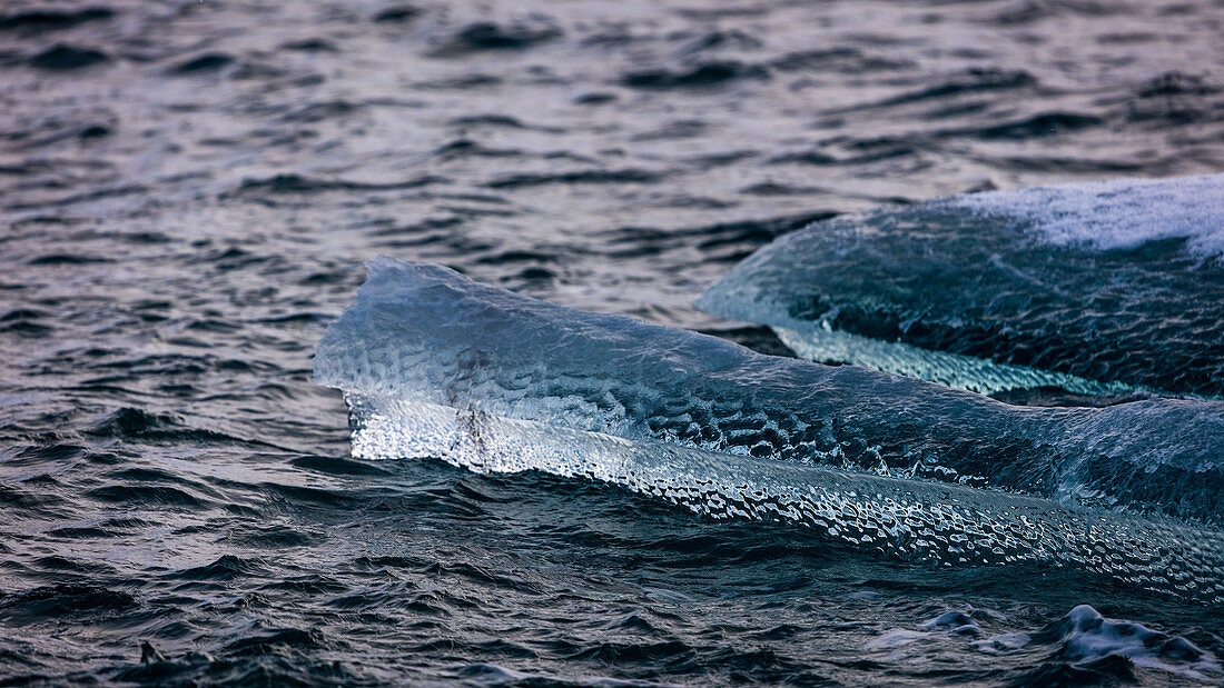 Close-up Of A Piece Of Translucent Ice On The Dark Arctic Sea In Spitsbergen, Svalbard