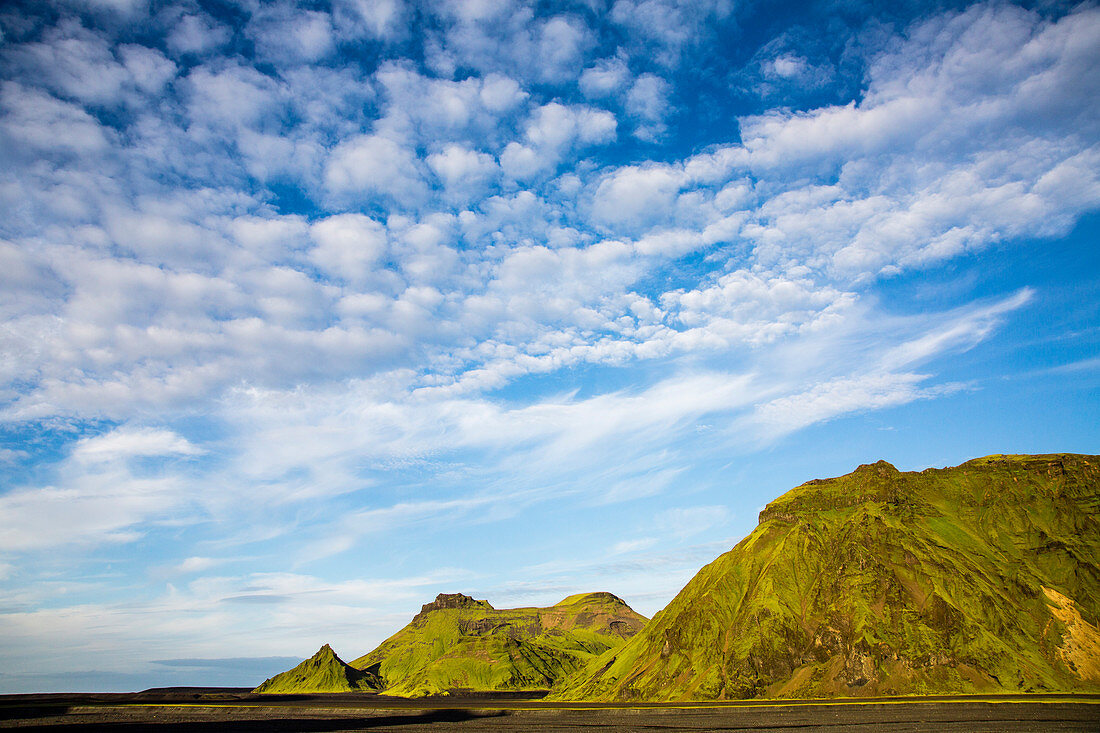 Green Former Volcano On A Black Sand Beach In South Iceland