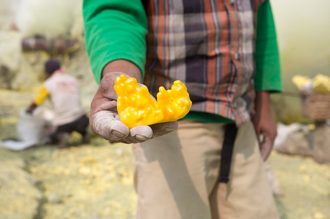 Close-up Of Worker's Hand Holding Sulfur In Java, Indonesia