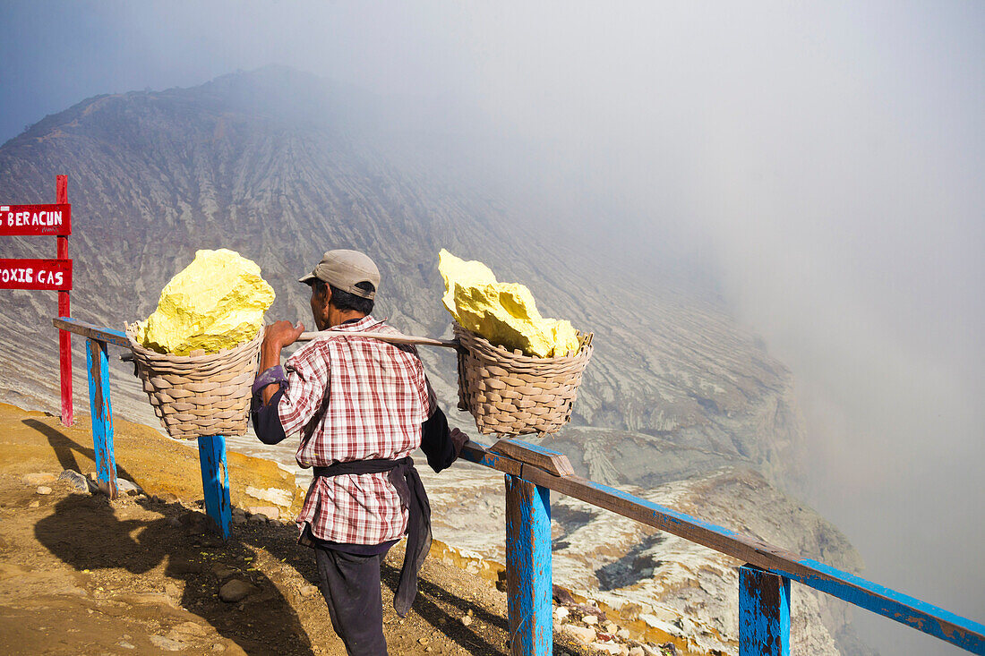 Workers Carrying The Blocks Of Sulfur In Two Baskets On Shoulder