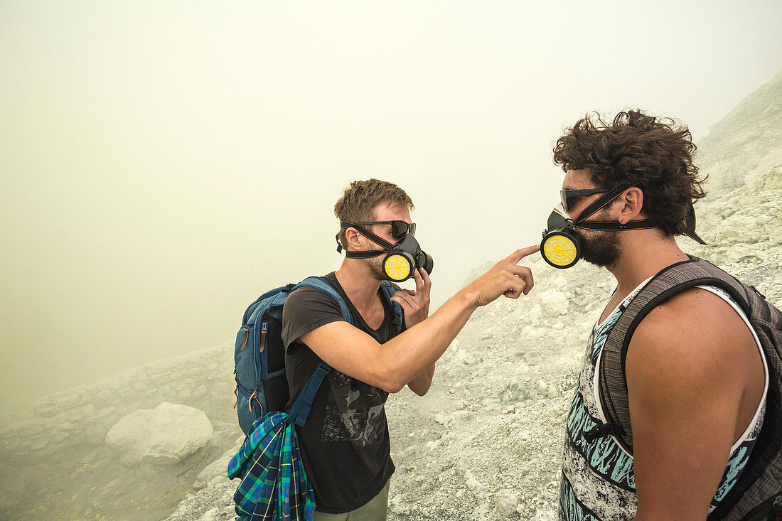 Two Male Hikers checking their air filters In Volcano Kawah Ijen, Java, Indonesia