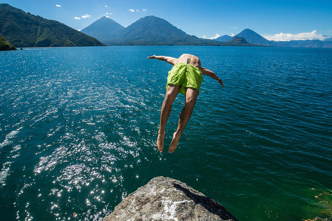 Athletic Man Backflipping In Lake Atitlan In Guatemala