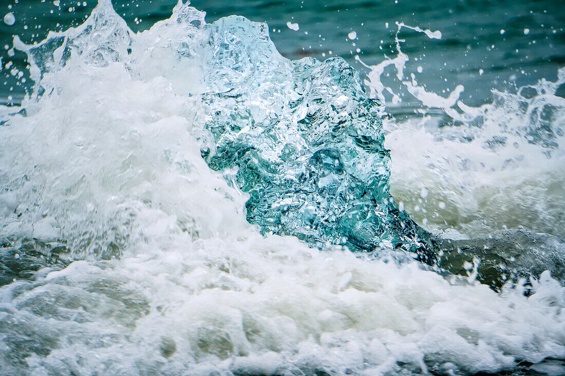 Waves Crash Over A Mostly Melted Iceberg On The Beach At Jokulsarlon, Iceland