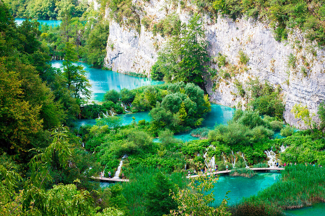 Plitvice Lakes, Croatia, Europe,  tourists walking on the pier in the middle of the turquoise lakes