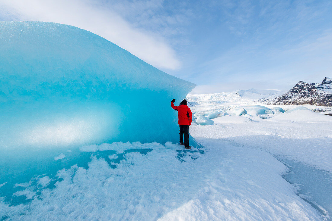 Fjallsarlon Gletscher Lagune, Ost-Island, Island, Mann mit roten Mantel bewundern den Blick auf die gefrorene Lagune im Winter, MR
