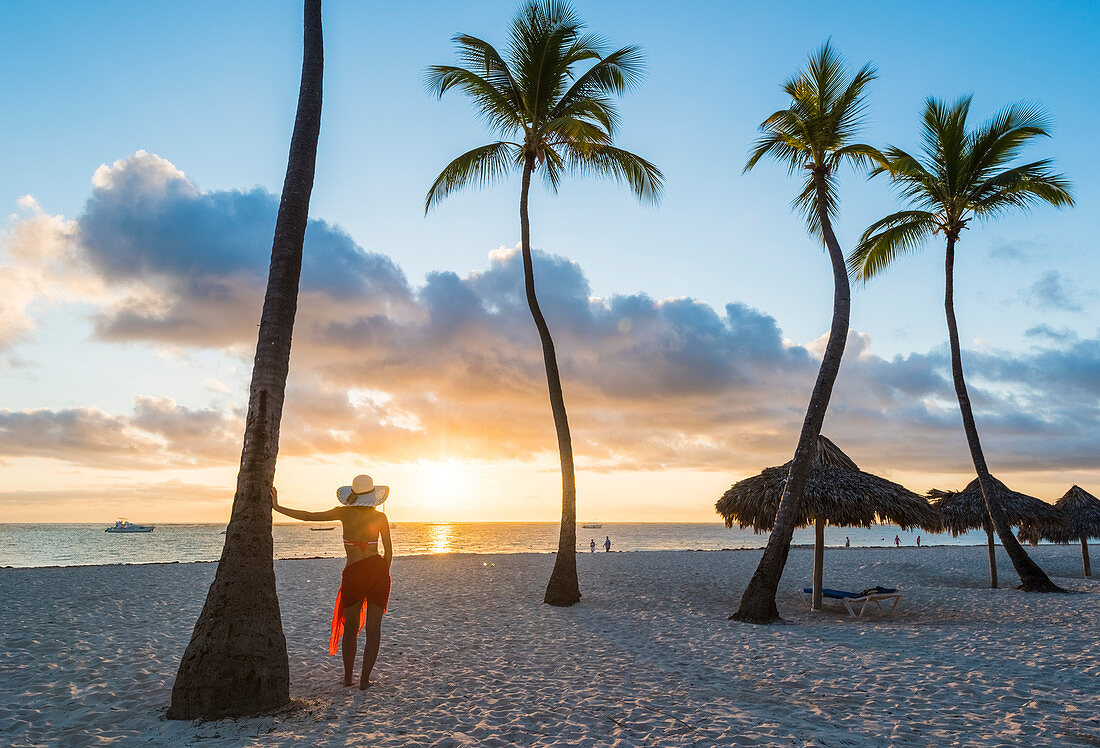Bavaro Beach, Bavaro, Higuey, Punta Cana, Dominikanische Republik, Frau bewundern den Sonnenaufgang auf einem Palmen gesäumten Strand, MR