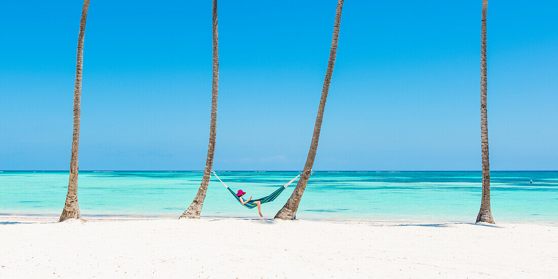 Juanillo Beach , playa Juanillo , Punta Cana, Dominican Republic,  Woman relaxing on a hammock on a palm-fringed beach , MR