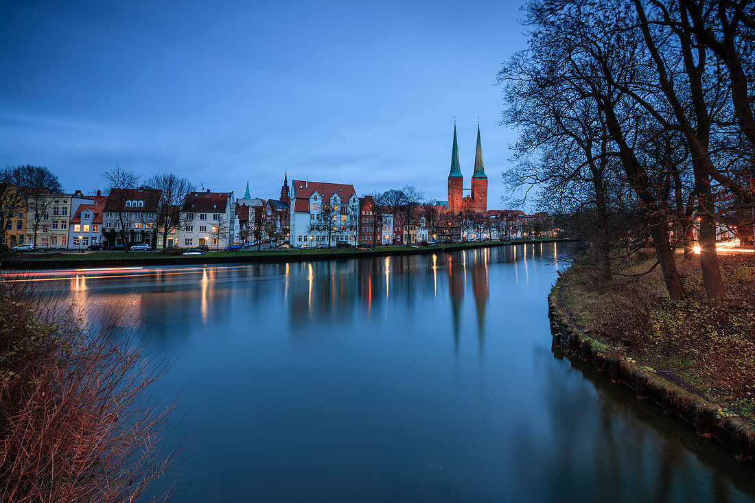 The lights of dusk on typical houses and the cathedral reflected in river Trave Lübeck Schleswig Holstein Germany Europe