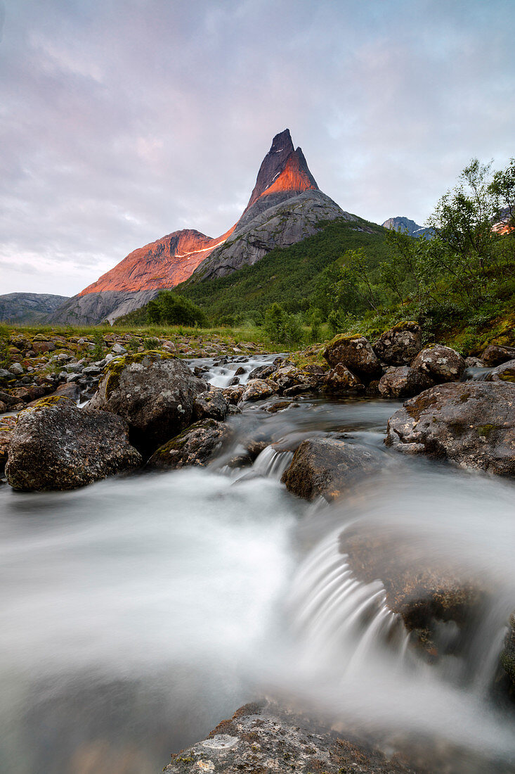 Wasserfall umrahmt die Stetinden Bergspitze beleuchtet von Mitternachtssonne Tysfjord Norwegen Europa