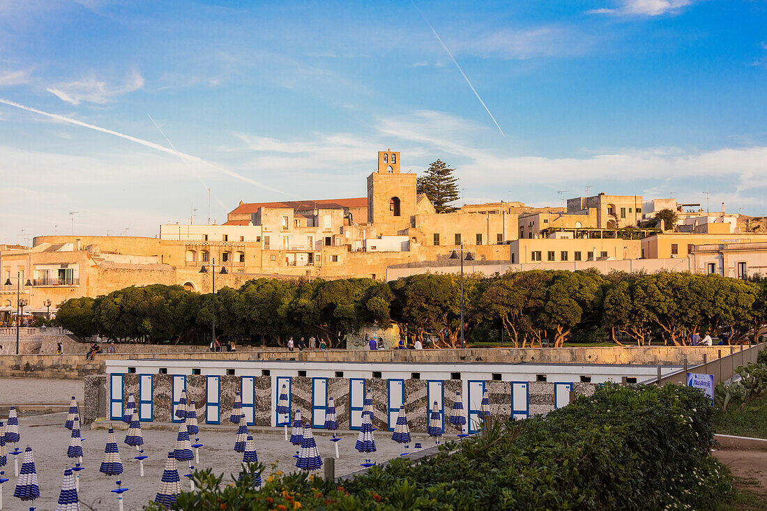 Beach umbrellas frame the medieval fortress of the old town Otranto province of Lecce Apulia Italy Europe