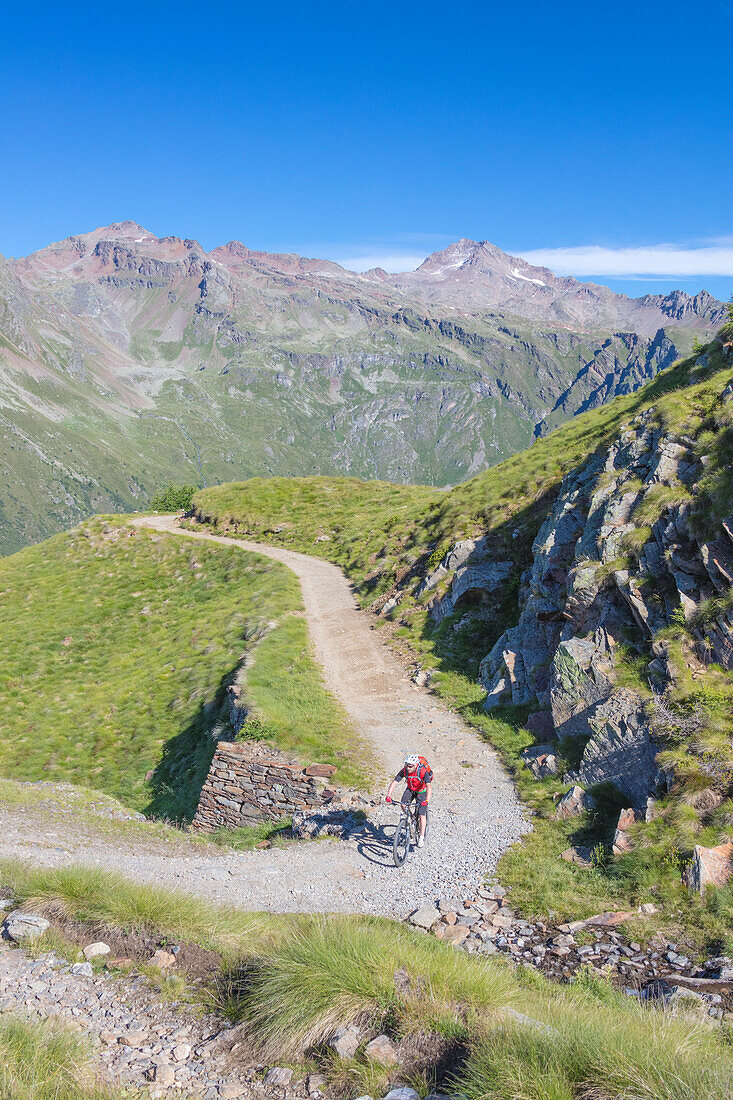 Mountainbike im grünen Tal umrahmt von felsigen Gipfeln Val di Viso Camonica Valley Provinz Brescia Lombardei Italien Europa