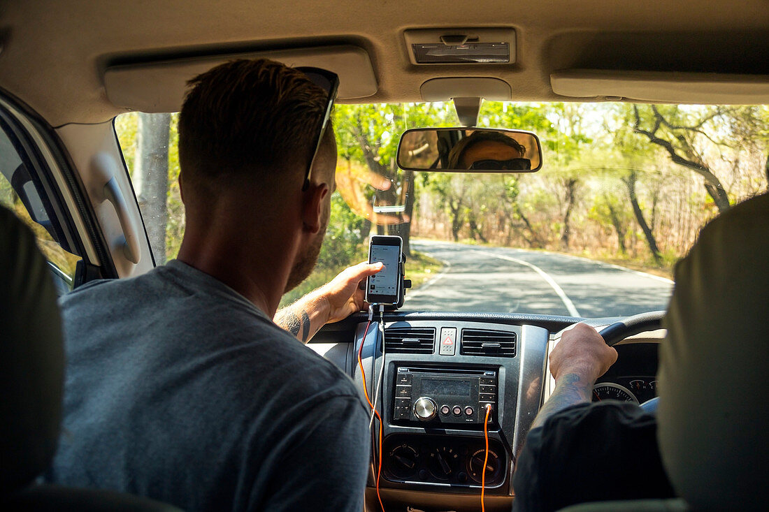 Two Young Men Using GPS Apps To Navigate Around Jakarta