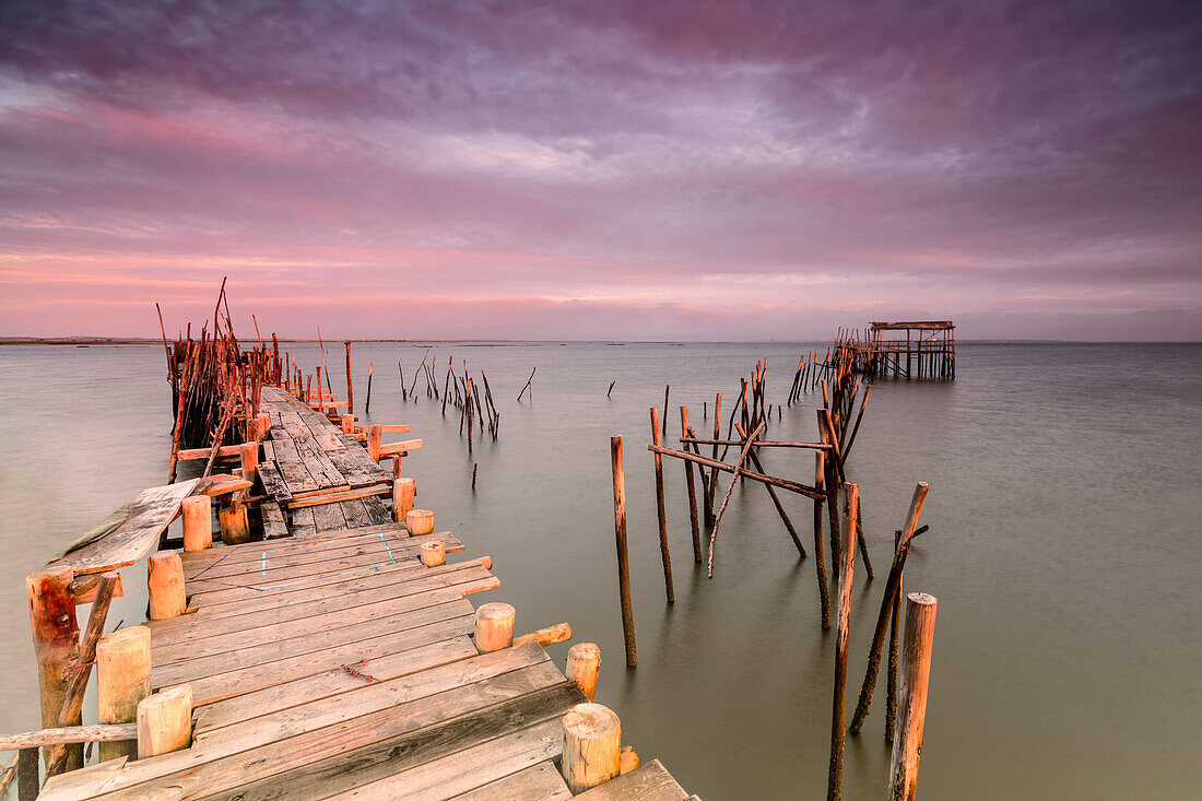 Pink sky at dawn on the Palafito Pier in the Carrasqueira Natural Reserve of Sado River, Alcacer do Sal, Setubal, Portugal, Europe