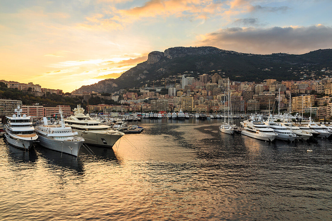 Vivid sunset over super yachts, glamorous harbour of Monaco (Port Hercules), from the sea, Monte Carlo, Monaco, Cote d'Azur, Mediterranean, Europe