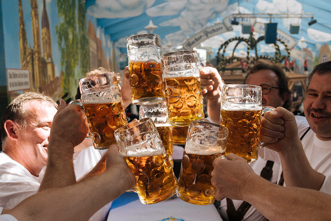 Raising beer mugs at Octoberfest, Munich, Bavaria, Germany