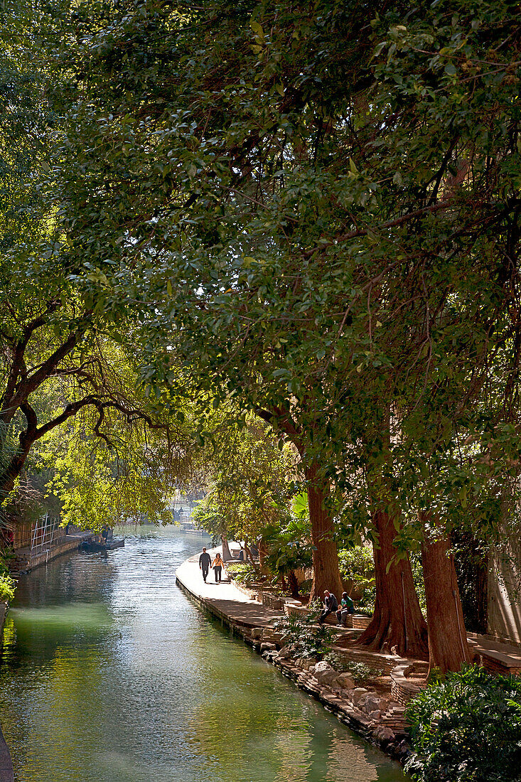 Walkers and joggers alike enjoy the quiet and shady sections of the San Antonio River, as it forms the Riverwalk through the heart of downtown.