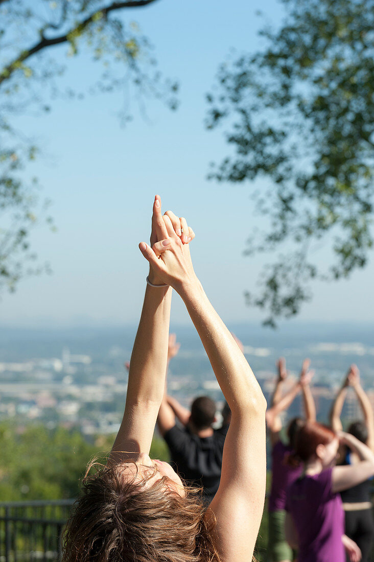 Hand mudras during a group yoga activity at a public park.