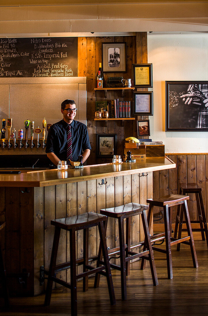 A bartender waits behind the bar at a restaurant near Anacortes, WA.