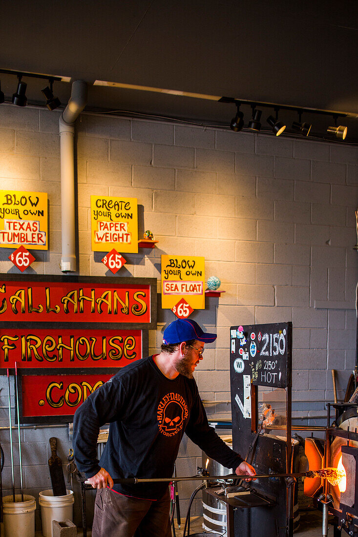 At a glass blowing studio on Whidbey Island, WA, a man makes a glass sculpture.