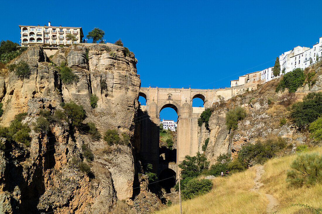 Ronda, Malaga Province, Andalusia, southern Spain The town on both sides of the El Tajo gorge, seen from below The bridge straddling the gorge is known as El Puente Nuevo, or the New Bridge