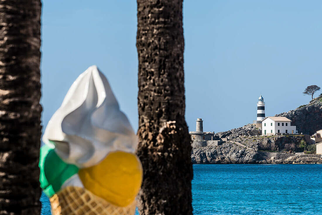 Eine große Eiswaffel als Werbung im  Hafen mit Blick auf den Leuchtturm, Port de Sóller, Mallorca, Spanien