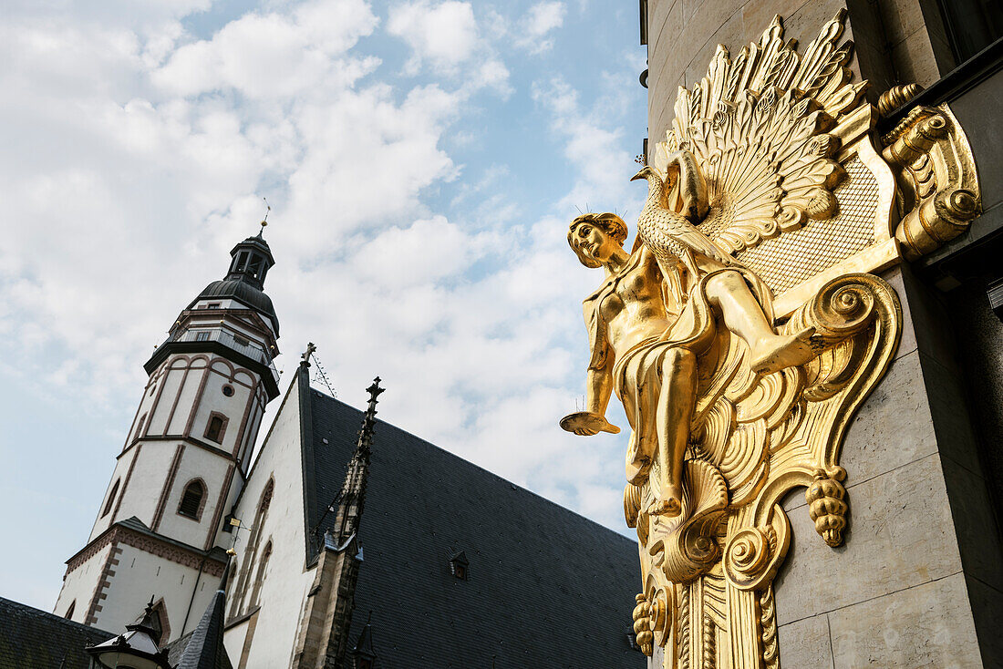 vergoldete Figur am Kaufhaus Topas, Commerzbank, im Hintergrund die Thomaskirche, Leipzig, Sachsen, Deutschland