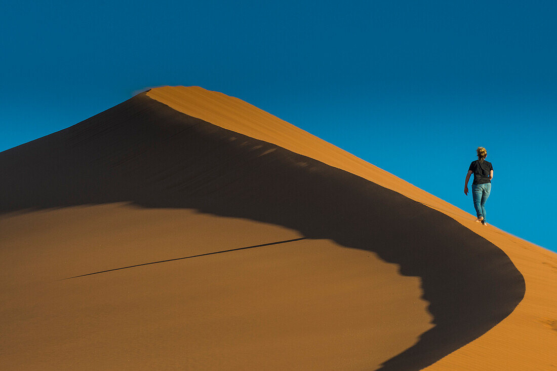 Frau wandert die riesige Sanddüne 45, Sossusvlei, Namib-Naukluft Nationalpark, Namibia, Afrika