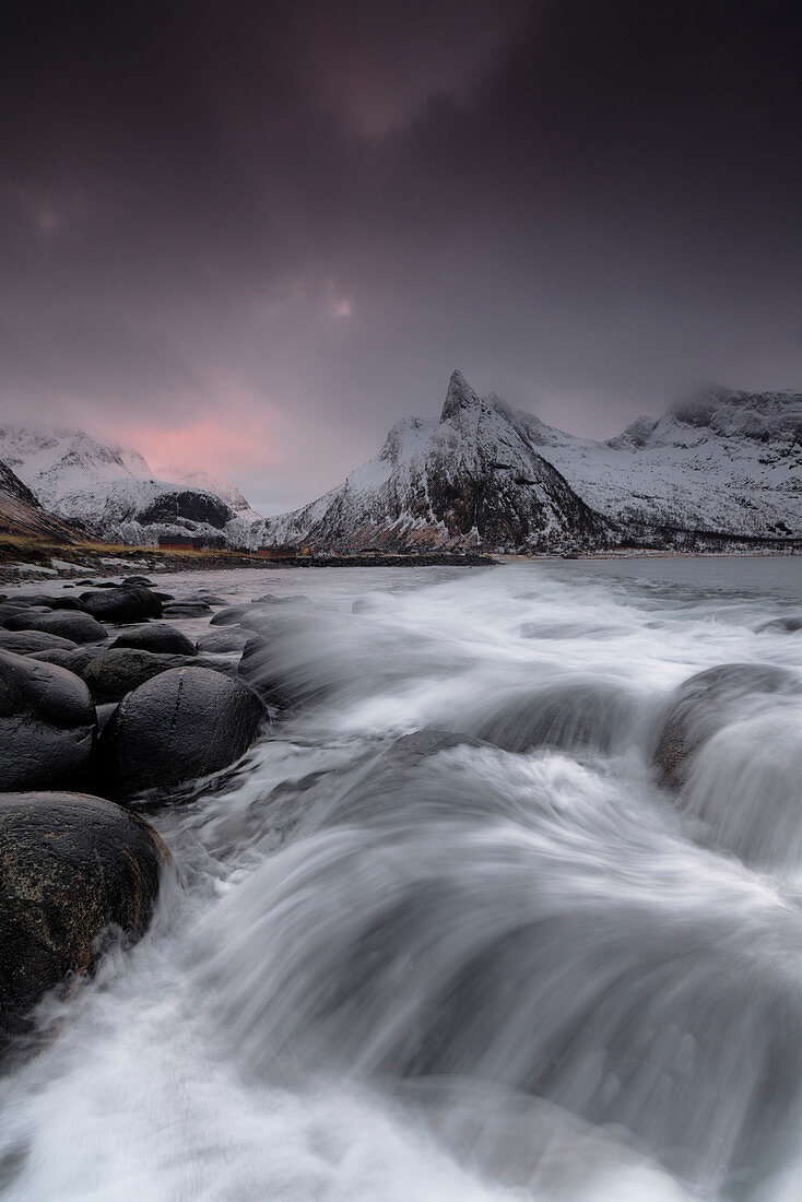 Dunkle Wolken über schneebedeckten Gipfeln und Wellen des kalten Meeres, Senja, Ersfjord, Kreis Troms, Norwegen, Skandinavien, Europa