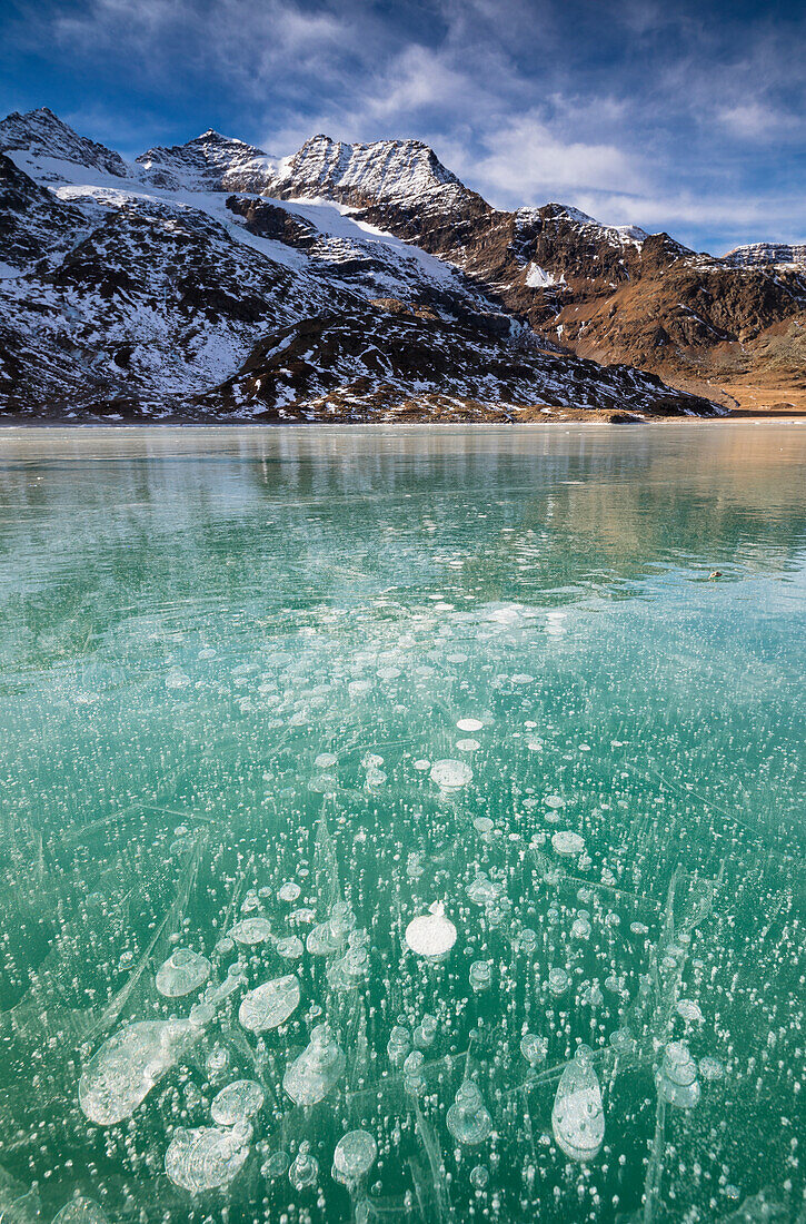 Eisbläschen im türkisfarbenen Wasser des gefrorenen weißen Sees (Lago Bianco), Bernina Pass, Kanton Graubünden, Engadin, Schweiz, Europa