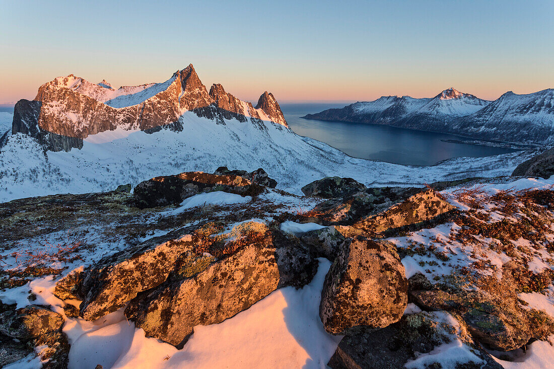 Blick auf das Dorf Husoy und das eisige Meer entlang der Oyfjorden vom Gipfel Hesten im Morgengrauen, Lenvik, Senja, Troms, Norwegen, Skandinavien, Europa