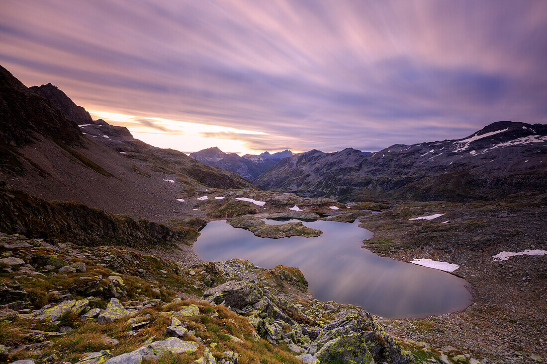 Fiery sky at dawn reflected in Lai Ghiacciato framed by peaks, Val Ursaregls, Chiavenna Valley, Valtellina, Lombardy, Italy, Europe