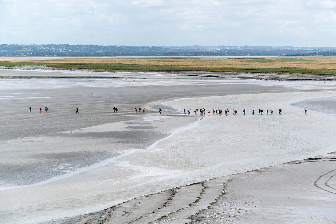 Die Leute gehen auf dem Sand bei Ebbe, Mont-Saint-Michel, Normandy, Frankreich, Europa