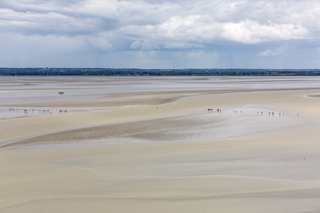 Die Leute gehen auf dem Sand bei Ebbe, Mont-Saint-Michel, Normandy, Frankreich, Europa