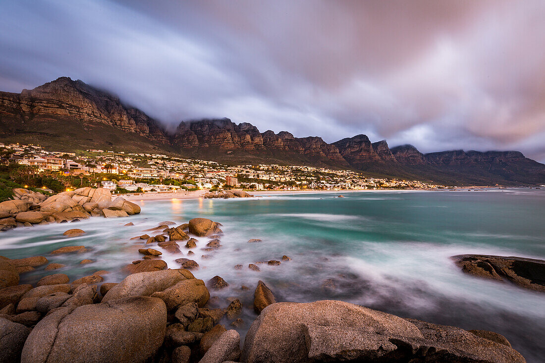 Langzeitbelichtung bei Sonnenuntergang in Camps Bay mit Wolke über Tafelberg und die Zwölf Apostel, Kapstadt, Südafrika, Afrika