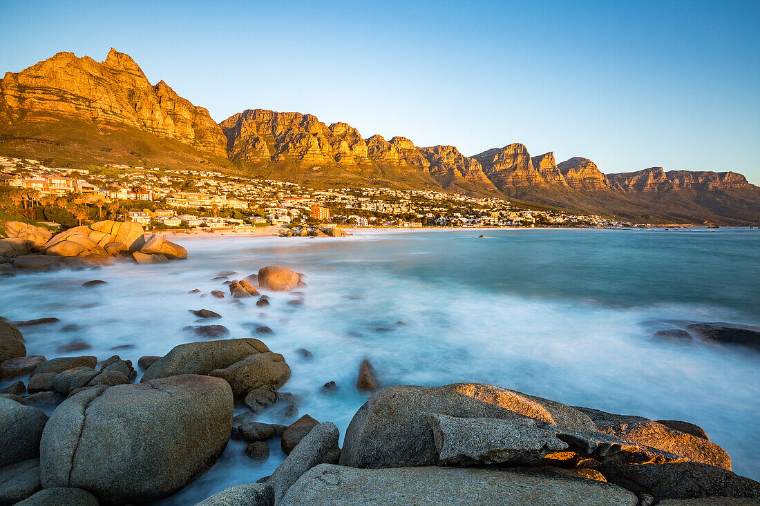Long exposure at sunset in Camps Bay with Table Mountain and its cable car on the left and the Twelve Apostles to the right, Western Cape, South Africa, Africa