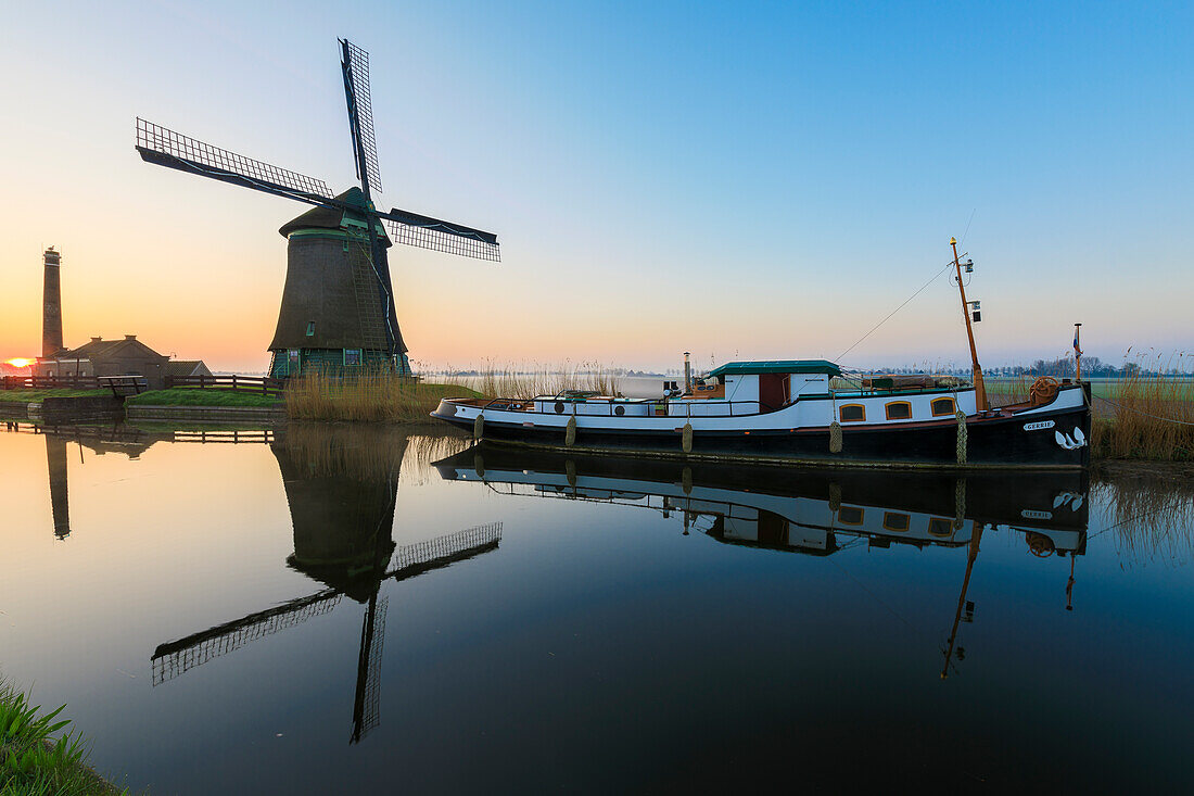 Typische Windmühle spiegelt sich im Kanal im Morgengrauen, Berkmeer, Gemeinde Koggenland, Nordholland, Niederlande, Europa