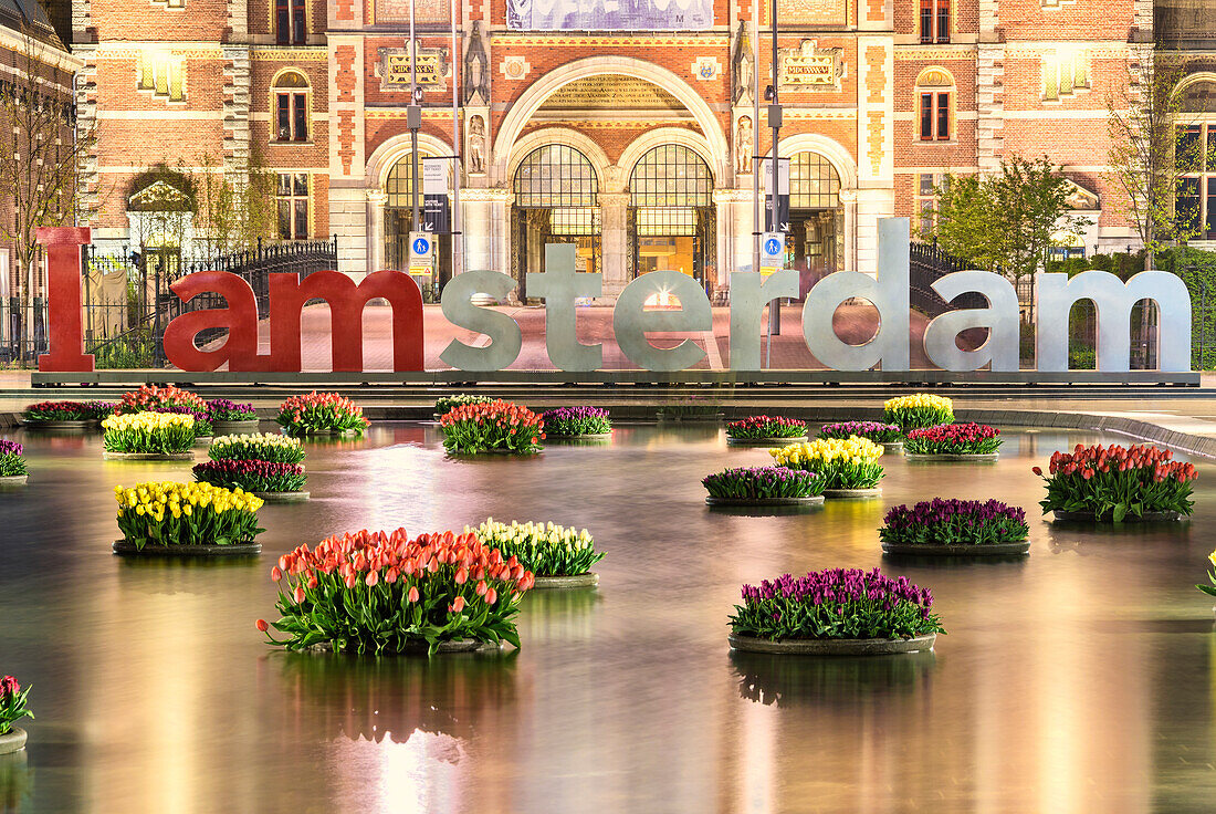 The National Rijksmuseum framed by vases of flowers floating in water, Amsterdam, Holland, The Netherlands, Europe