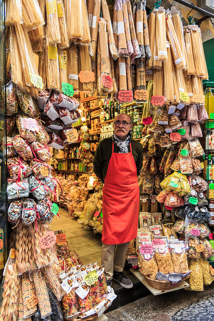 Grocery store owner proudly stands at shop front with pasta, City of Naples Historic Centre, UNESCO World Heritage Site, Naples, Campania, Italy, Europe