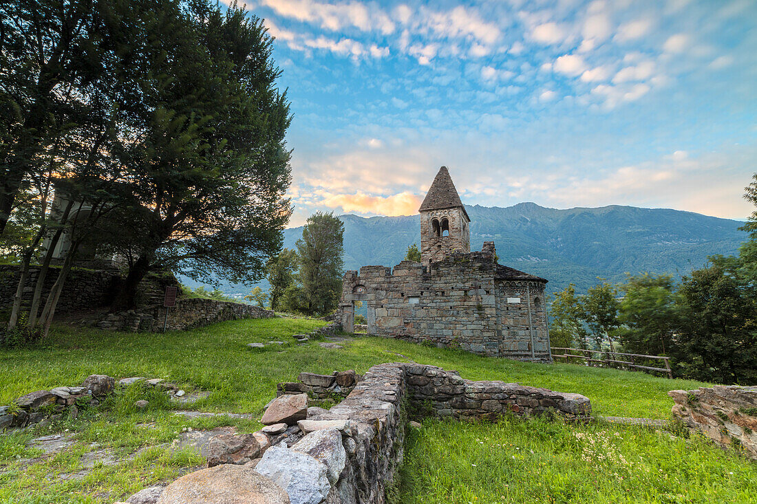 Green meadows frame the Abbey of San Pietro in Vallate at sunset, Piagno, Sondrio province, Lower Valtellina, Lombardy, Italy, Europe