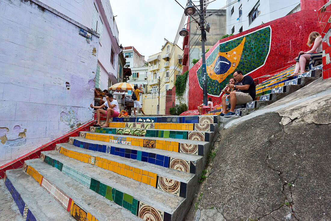 Tourists sitting on Selaron Steps, 215 decorated steps the work of artist Jorge Selaron, Rio de Janeiro, Brazil, South America