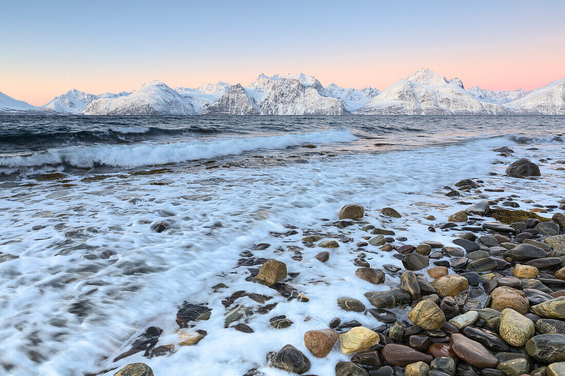 Die Wellen brechen am Strand mit Blick auf die Lyngen Alpen bei Sonnenaufgang, Hammarvika, Lyngenfjord, Lyngen Alpen, Troms, Norwegen, Lappland, Europa